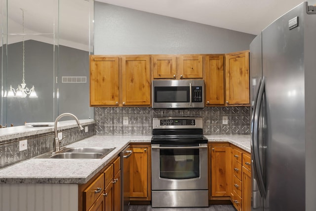 kitchen with visible vents, appliances with stainless steel finishes, vaulted ceiling, light countertops, and a sink