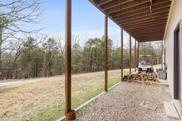 view of yard with a carport and a forest view