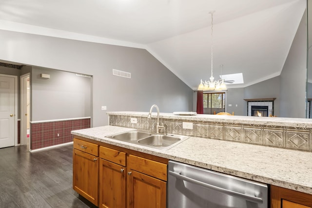 kitchen featuring dark wood-type flooring, a sink, visible vents, vaulted ceiling, and dishwasher