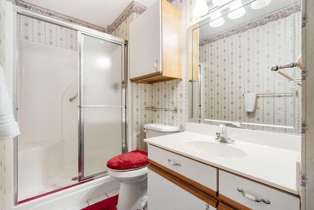 full bath with a stall shower, vanity, toilet, and wallpapered walls