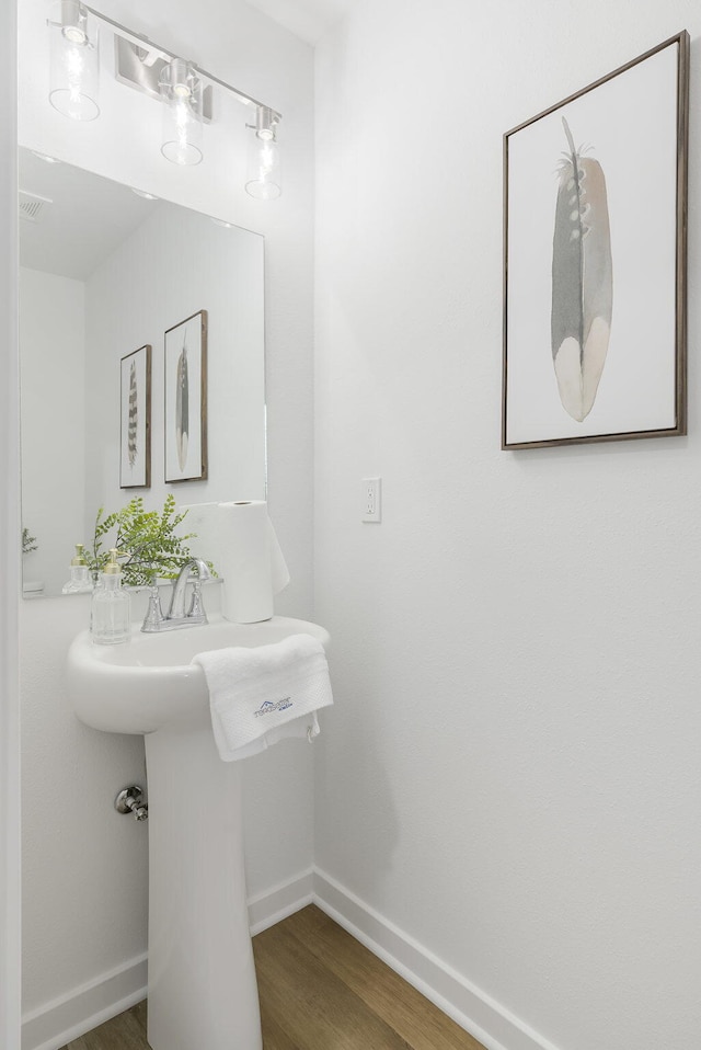 bathroom with wood finished floors and baseboards