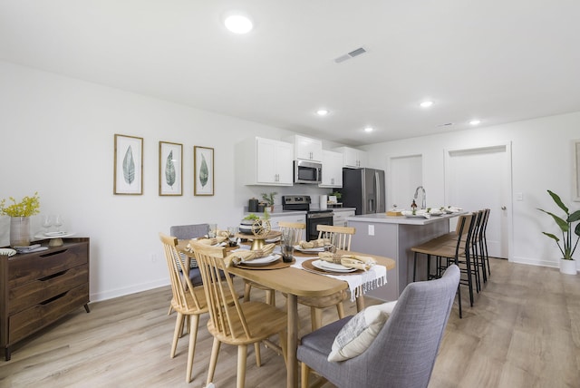 dining area with light wood-type flooring, baseboards, visible vents, and recessed lighting