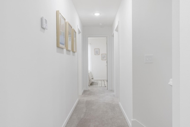 hallway with light carpet and baseboards