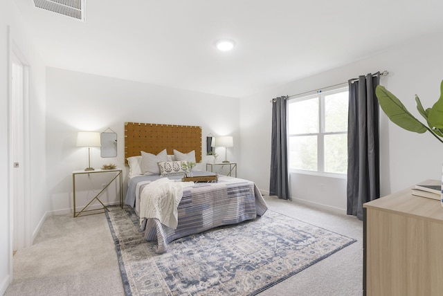 bedroom featuring light colored carpet, visible vents, and baseboards