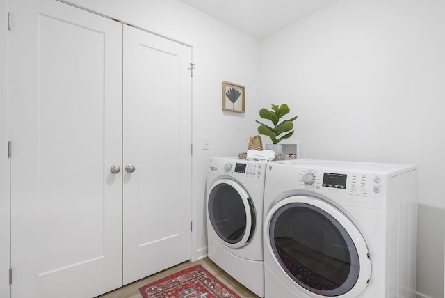 washroom with laundry area, light wood-style flooring, and washing machine and clothes dryer