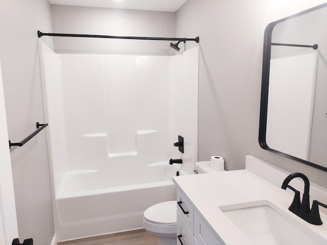 full bathroom with  shower combination, wood finished floors, vanity, and toilet