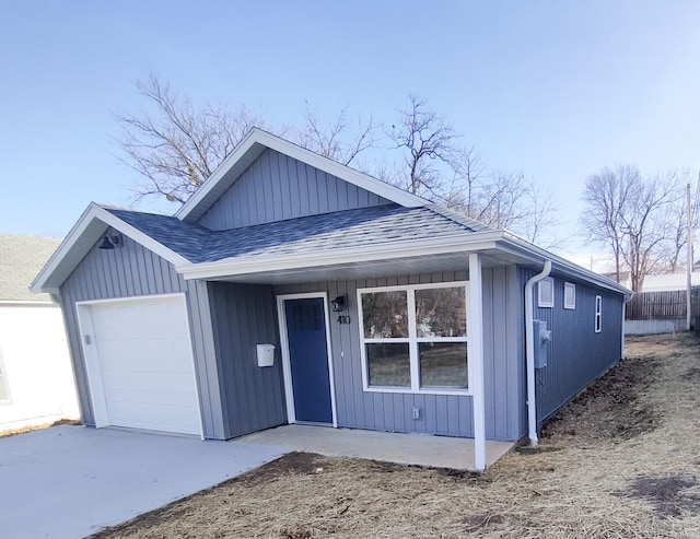 view of front of home featuring a garage and a shingled roof