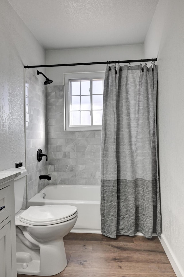 bathroom with a textured wall, shower / bath combo with shower curtain, wood finished floors, and toilet