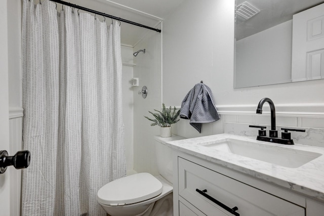 full bathroom featuring a shower with shower curtain, visible vents, vanity, and toilet