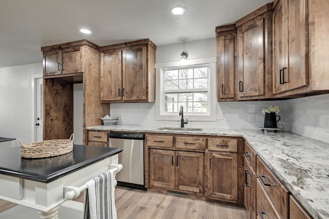 kitchen featuring a textured ceiling, recessed lighting, a sink, dishwasher, and light wood finished floors