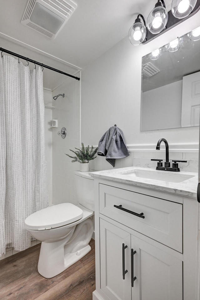 bathroom featuring toilet, visible vents, and wood finished floors