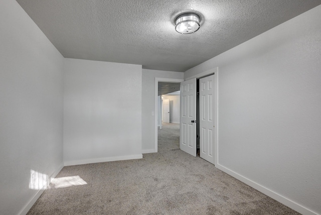 unfurnished bedroom with a textured ceiling, a closet, carpet flooring, and baseboards