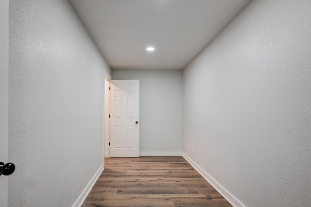 hallway with baseboards and dark wood-type flooring