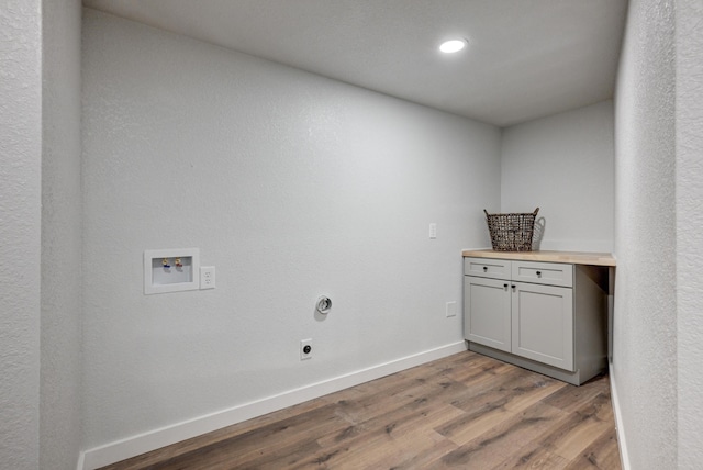 laundry area with washer hookup, cabinet space, electric dryer hookup, wood finished floors, and baseboards