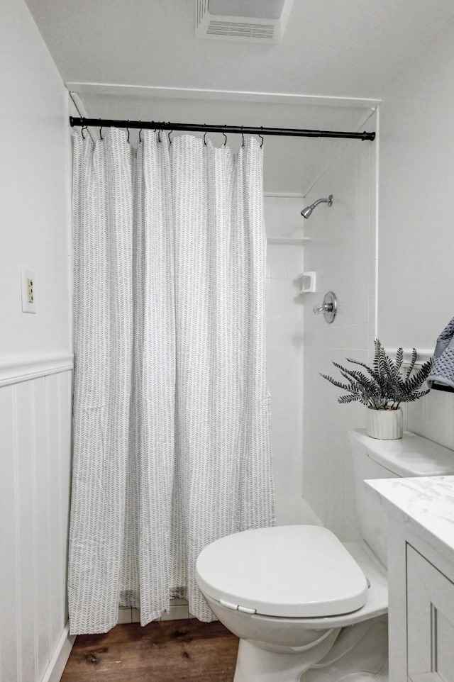 full bath with toilet, a shower with curtain, visible vents, and wood finished floors