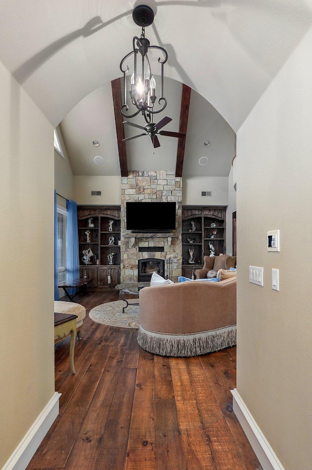 living room featuring lofted ceiling, baseboards, dark wood-type flooring, and a stone fireplace