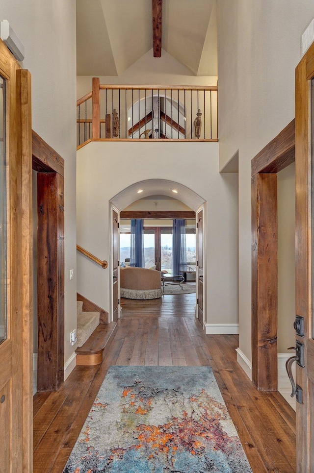 foyer featuring hardwood / wood-style floors, stairs, beam ceiling, and french doors