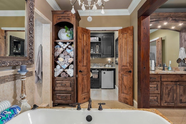 full bath with vanity, ornamental molding, a bath, and tile patterned floors