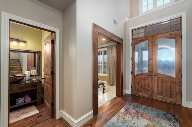 entryway featuring hardwood / wood-style flooring, visible vents, baseboards, french doors, and a wealth of natural light