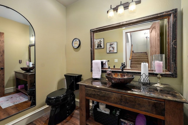 bathroom featuring wood finished floors, vanity, toilet, and baseboards