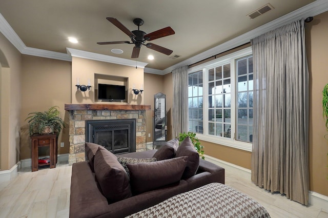 living room with ornamental molding, visible vents, a fireplace, and baseboards