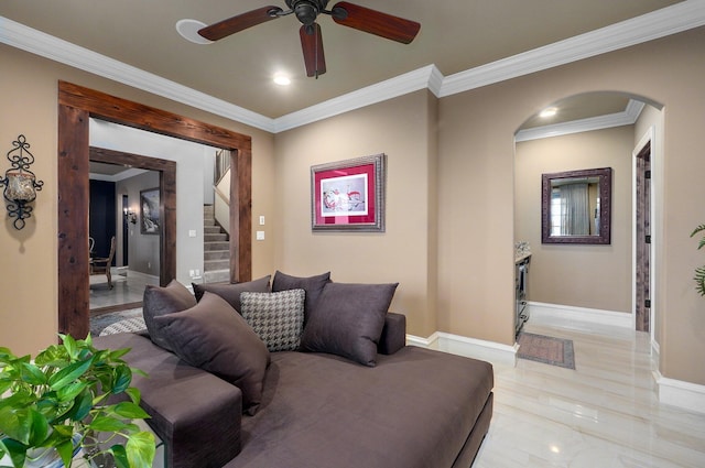 living room featuring arched walkways, crown molding, and baseboards