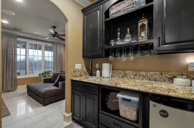 bar with arched walkways, crown molding, visible vents, ceiling fan, and a bar