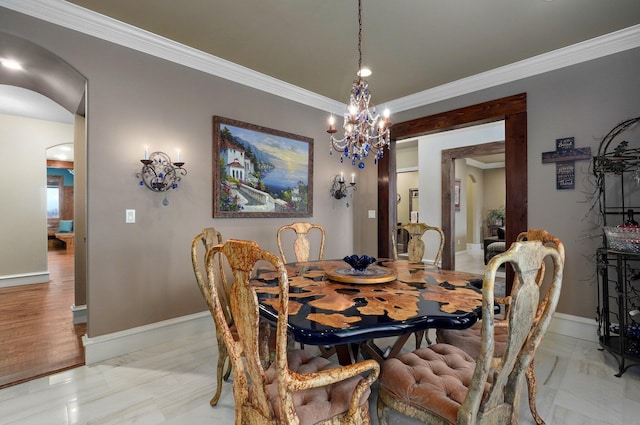 dining area featuring arched walkways, a notable chandelier, crown molding, and baseboards