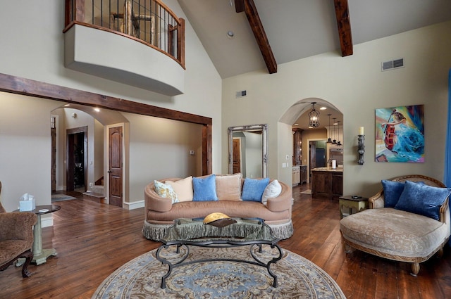 living room with visible vents, arched walkways, hardwood / wood-style floors, high vaulted ceiling, and beam ceiling