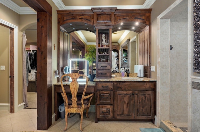 bar featuring arched walkways, light tile patterned flooring, a sink, and crown molding