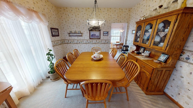 dining area featuring light colored carpet, baseboards, and wallpapered walls