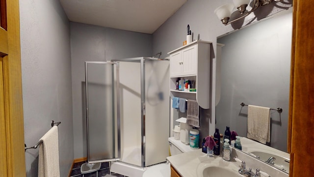 bathroom featuring vanity, a shower stall, and toilet