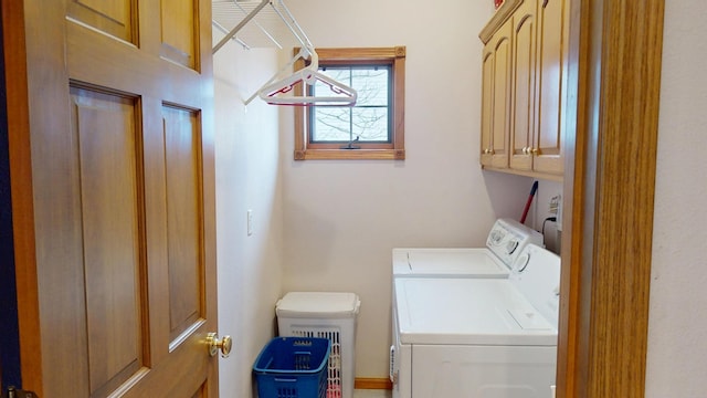 clothes washing area featuring cabinet space and washer and dryer