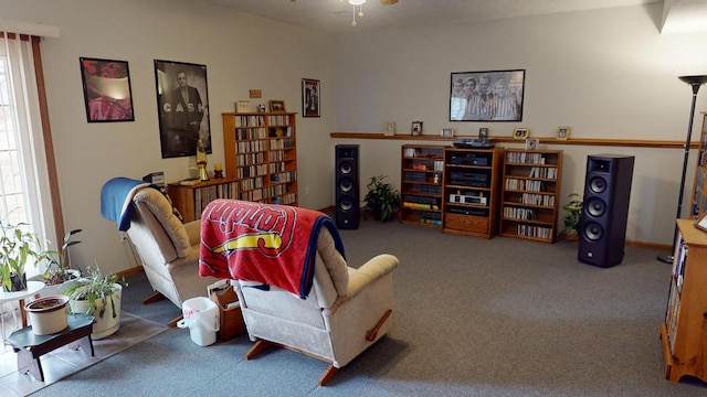 living area featuring carpet floors, a wealth of natural light, ceiling fan, and baseboards