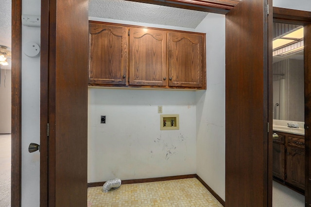 laundry room featuring washer hookup, cabinet space, hookup for an electric dryer, a textured ceiling, and baseboards