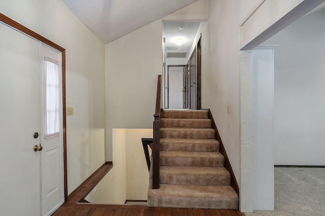 stairway featuring visible vents and baseboards