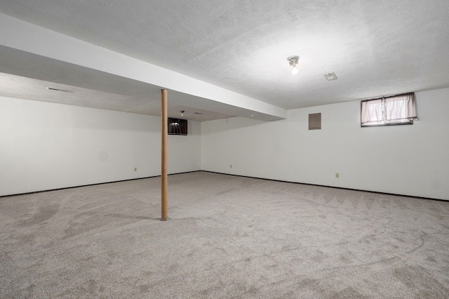 basement with a textured ceiling and carpet flooring