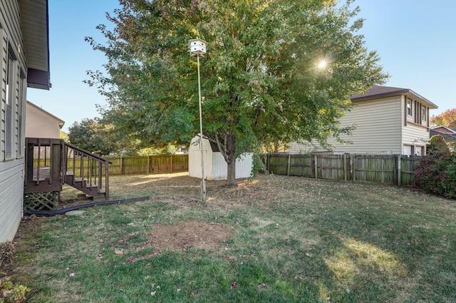 view of yard featuring an outbuilding, a fenced backyard, stairway, and a shed