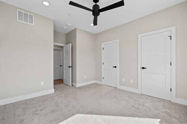 unfurnished bedroom with carpet floors, baseboards, visible vents, and a ceiling fan