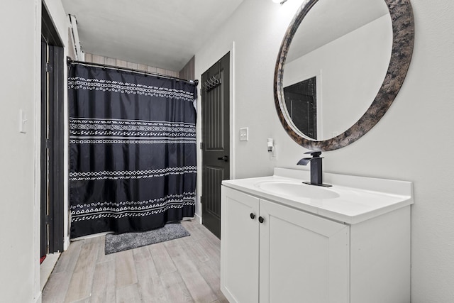 bathroom with wood tiled floor, vanity, and a shower with shower curtain