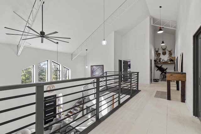 hallway with high vaulted ceiling and an upstairs landing