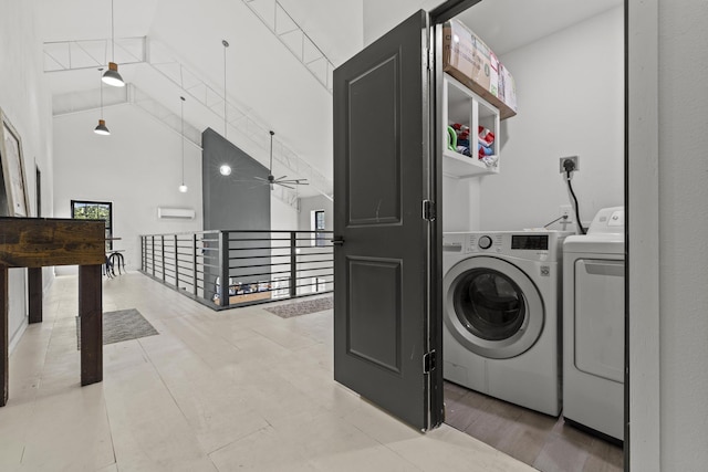 clothes washing area featuring a towering ceiling, laundry area, washer and clothes dryer, and a ceiling fan