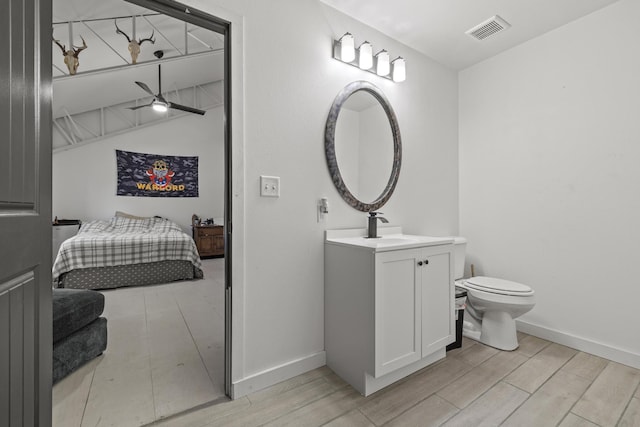 bathroom with toilet, vanity, visible vents, and wood finish floors