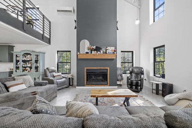 living room with a wall unit AC, a fireplace, and a high ceiling