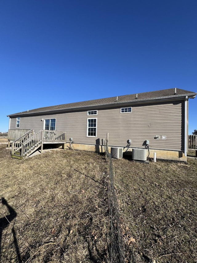 rear view of property with cooling unit and a deck