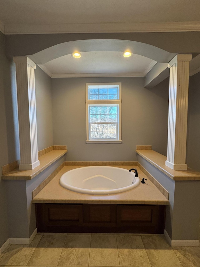 bathroom with ornate columns, a bath, and crown molding