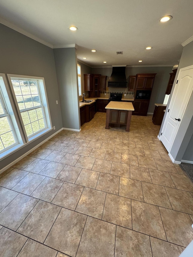 kitchen featuring light tile patterned floors, light countertops, custom exhaust hood, and crown molding