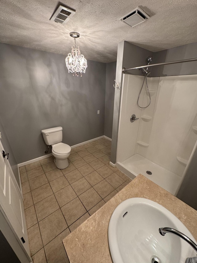 bathroom featuring tile patterned flooring, visible vents, a shower, and a sink