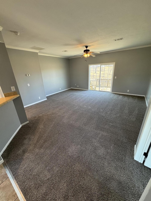 carpeted spare room with baseboards, visible vents, ceiling fan, and ornamental molding