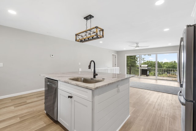 9 View Table Rock Lndg Unit 12, Branson West, MO 65737 - kitchen featuring appliances with stainless steel finishes, open floor plan, white cabinetry, light stone countertops, and a kitchen island with sink
